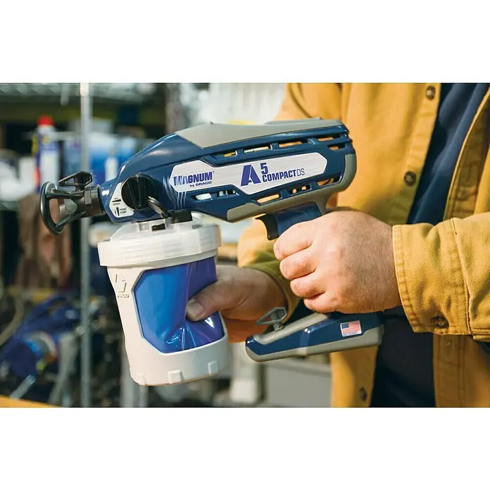 Graco Magnum Sistema de pulverización de pintura Compact A5DS - Velocidad de trabajo: 6 m²/min - Primer plano de un pulverizador de pintura Graco Magnum A5 Compact DS que está sosteniendo una persona.