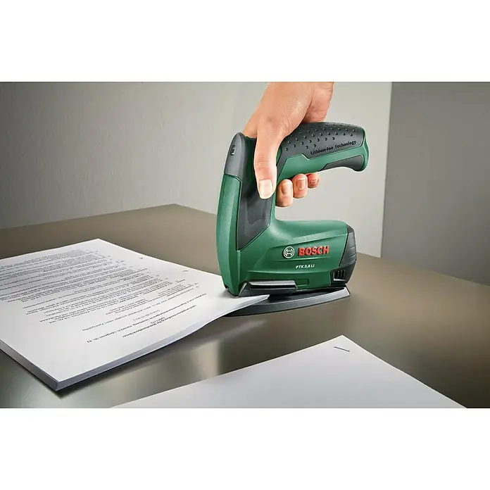 Bosch Heftgerät - Passend für: Bosch Akku-Tacker PTK 3,6 LI - Der Bosch PTK 3,6 LI Akku-Tacker im Einsatz. Das grüne Elektrowerkzeug tackert Papier auf einer silbernen Oberfläche. Ideal für Hobby und Beruf.