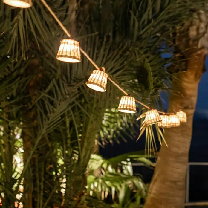 New Garden Guirnalda luminosa LED Aurora - Para exterior, 8 m, Color de luz: Blanco neutro - Guirnalda de luces con pequeñas pantallas colgadas entre palmeras, creando un ambiente acogedor.