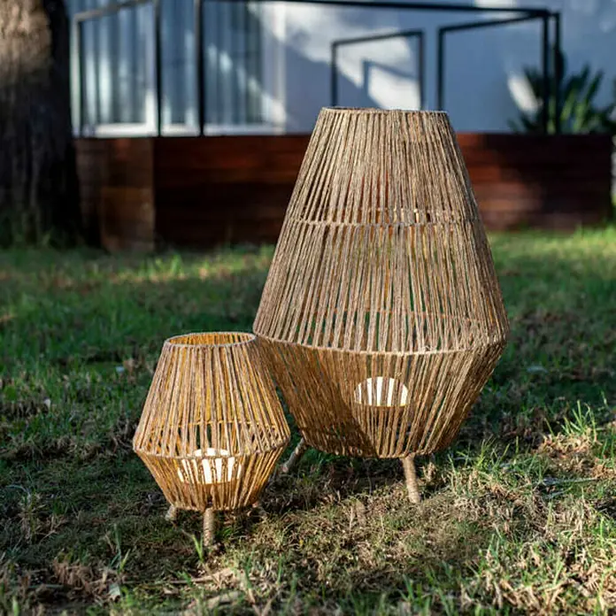 New Garden Sisine Außenstehleuchte Sisine - B x H: 48 x 72 cm - Nahaufnahme von zwei geflochtenen Laternen unterschiedlicher Größe auf einer Rasenfläche. Sie sind aus natürlichem Material gefertigt.