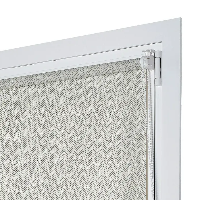 Estor enrollable Espiga - An x Al: 120 x 180 cm - Primer plano de un estor enrollable con un patrón de espiga gris, enmarcado en un marco de ventana blanco, combinando control de luz y diseño.