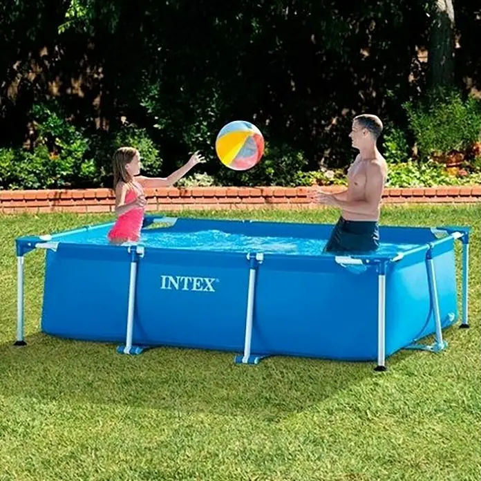 Intex Piscina Frame Family - L x An x Al: 220 x 150 x 60 cm, Azul, 1.662 l - Una familia juega con una pelota de colores en una piscina azul Intex sobre el suelo en el jardín.