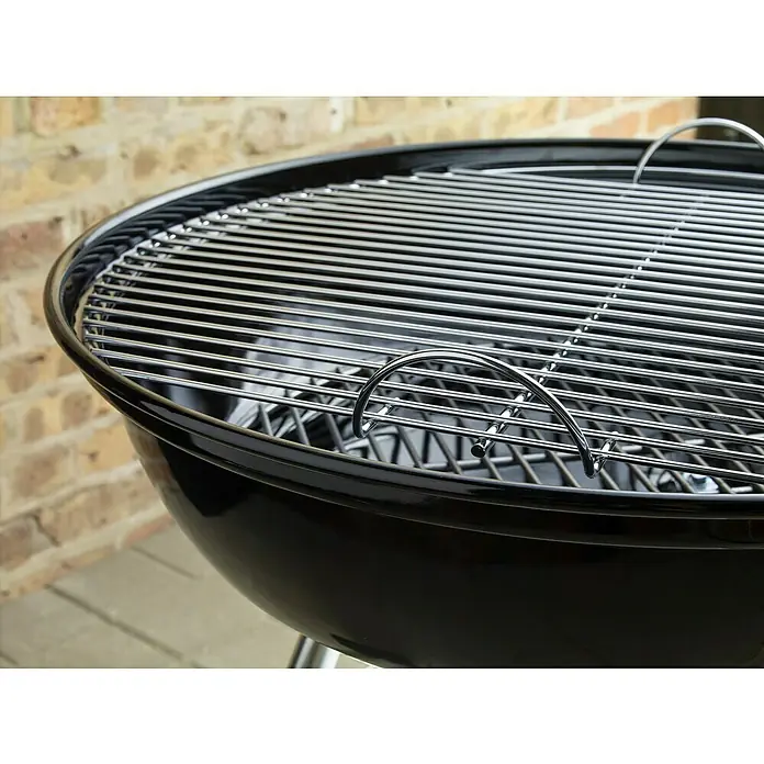 Weber Barbacoa redonda con tapa Compact Kettle - Diámetro de la superficie de la parrilla: 47 cm, Negro - Primer plano de una parrilla de carbón negra con una rejilla cromada, ideal para barbacoas de verano al aire libre.