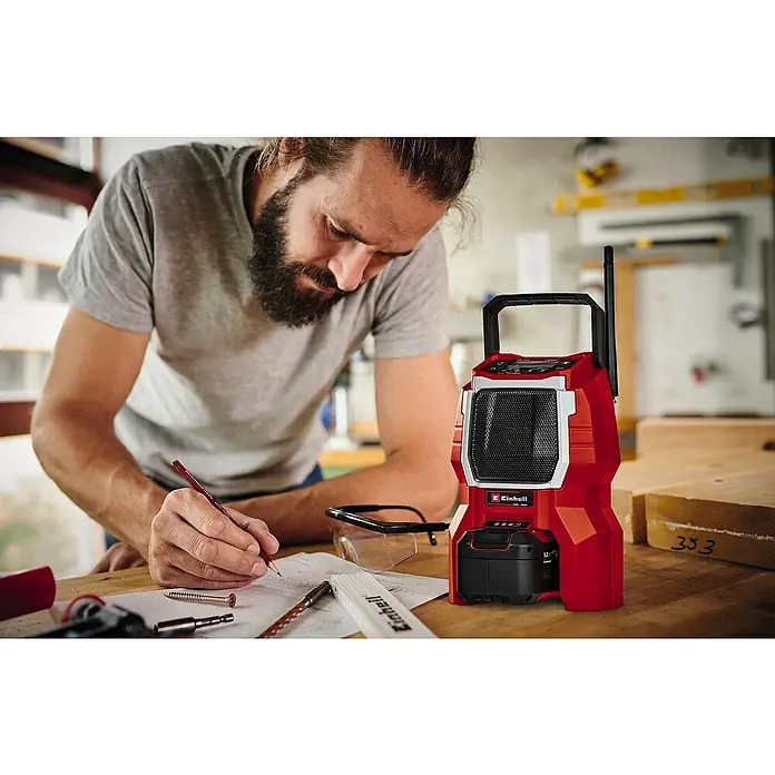 Einhell Power X-Change 18V Akku-Baustellenradio TC-RA 18 Li-Solo - Schwarz/Rot, Akkuspannung: 18 V, Anzahl Akkus: Ohne Akku, Frequenz: 87,5 - 108,0 kHz (FM) - Handwerker plant mit dem Einhell Akku-Baustellenradio im Hintergrund.