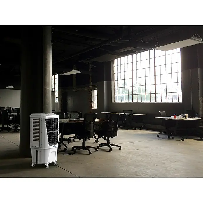 Purline Rafy Climatizador evaporativo 180 - Blanco, Altura: 118 cm, 160 W - Enfriador de aire en una oficina moderna. La unidad portátil es blanca y se encuentra junto a un pilar en una oficina diáfana.
