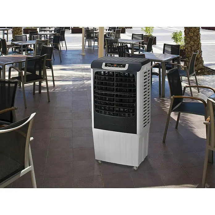 Purline Rafy Climatizador evaporativo 185 - Blanco/Negro, Altura: 104 cm, Potencia frigorífica: 200 W, Tamaño de la estancia: 80 m² - Un enfriador de aire portátil blanco y negro se encuentra en un patio, rodeado de mesas y sillas, ofreciendo confort en días calurosos.