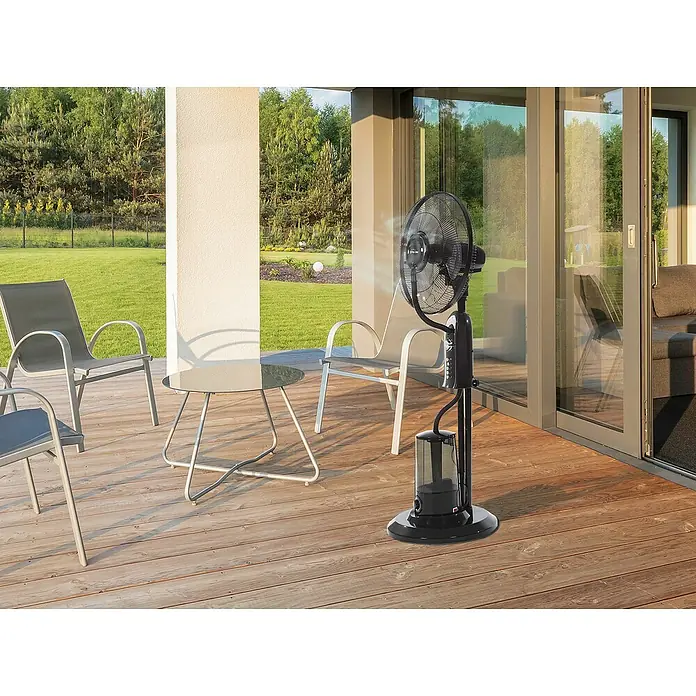 Purline Misty Ventilador de pie 1 - Negro, Altura: 125 cm - Un ventilador de nebulización de pie en una terraza de madera ofrece refrigeración y refresco en un día caluroso, perfecto para la relajación al aire libre.