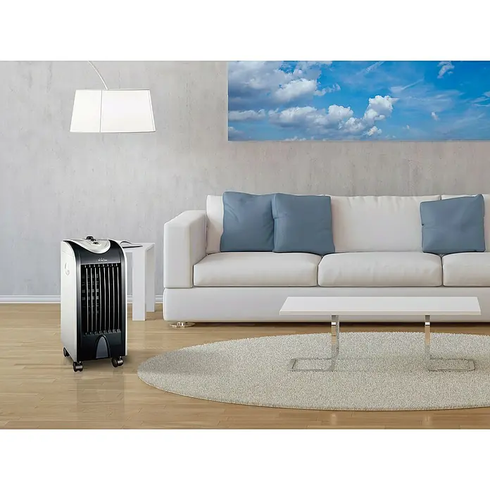 Purline Rafy Climatizador evaporativo 51 - Blanco/Negro, Altura: 58 cm, 75 W - Un elegante enfriador de aire portátil en blanco y negro se encuentra en una sala de estar modernamente amueblada.