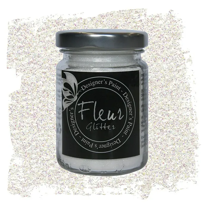 Fleur Purpurina Glitter - Blanco arcoíris, 90 g, Brillante - Primer plano de un bote de purpurina Fleur Designer's Paint rodeado de brillantes partículas de purpurina blancas e iridiscentes.