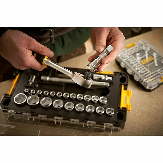 Stanley FatMax Set de llaves de vaso FMMT98103-1 - 26 pzs., Tamaño de accionamiento: ½″ - Primer plano de un juego de vasos con carraca sujetado por manos. Este kit de herramientas es perfecto para reparaciones y bricolaje.