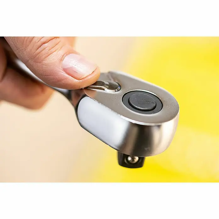 Stanley FatMax Set de llaves de vaso FMMT82680-0 - 22 pzs., Tamaño de accionamiento: ⅜″ - Primer plano de una mano operando una llave de carraca, destacando el acabado cromado y la función mecánica de la herramienta.