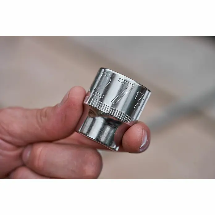 Stanley FatMax Set de llaves de vaso FMMT82680-0 - 22 pzs., Tamaño de accionamiento: ⅜″ - Primer plano de un vaso brillante de 27 mm sujetado en la mano. Ideal para profesionales y aficionados al bricolaje.