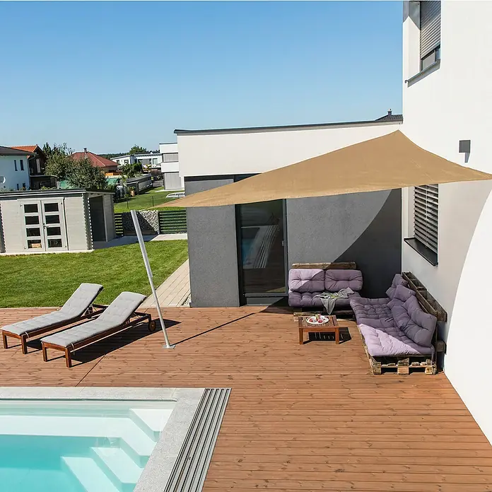 Windhager Sonnensegel Capri - L x B: 5 x 5 m, Schilf, Dreieckig - Ein stilvolles schattenspendendes Sonnensegel auf einer Holzterrasse neben einem Pool, ideal für entspannte Stunden im Freien.