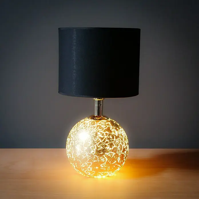 Tween Light Tischleuchte Gala - 40 W, Schwarz/Gold, G9 - Nahaufnahme einer Tischlampe mit einem schwarzen Lampenschirm und einem kugelförmigen, goldfarbenen Lampenfuß auf einem Tisch.