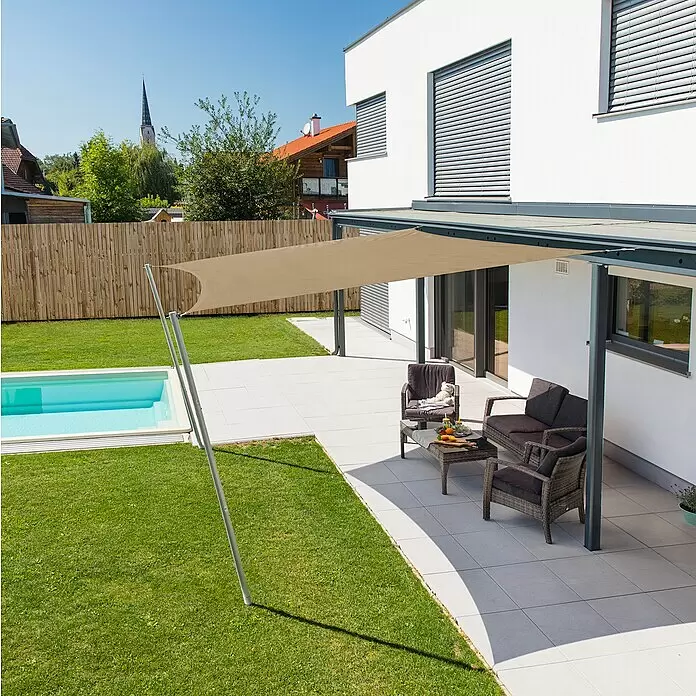 Windhager Sonnensegel - Taupe, B x L: 4 x 4 m - Ein beiger Sonnensegel spendet Schatten über einer modernen Terrasse mit dunklen Gartenmöbeln, neben einem kleinen Pool und einem Haus.