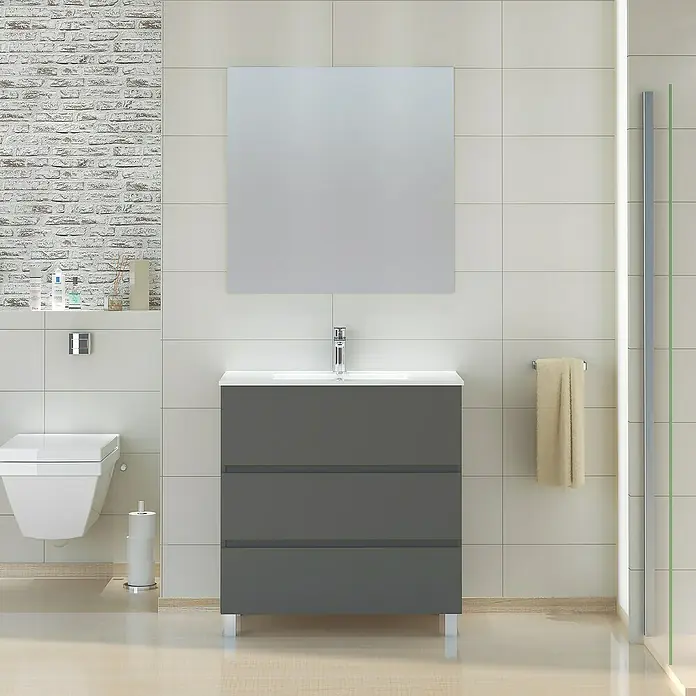 Artysan Mueble bajo de lavabo Patri - 46 x 80 x 85 cm, Gris - Lavabo gris con tres cajones y superficie blanca, espejo cuadrado en la pared e inodoro suspendido a la izquierda.