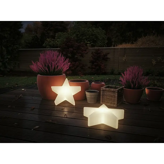Paulmann Plug & Shine LED-Dekoleuchte Star - Weiß, L x B x H: 10 x 40 x 40 cm - Leuchtende Sternlampen inmitten von Blumentöpfen auf einer dunklen Holzterrasse, die eine gemütliche Gartenatmosphäre schaffen.