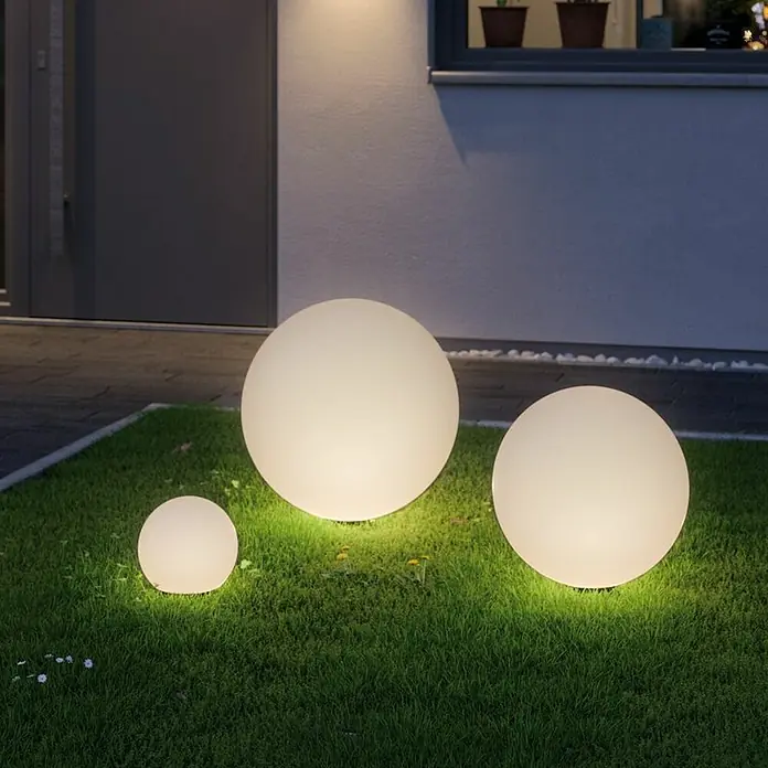 Paulmann Plug & Shine LED-Außenleuchte - Durchmesser: 40 cm, 1-fach, Warmweiß, IP67 - Drei runde Gartenleuchten unterschiedlicher Größe erhellen den Rasen vor einem modernen Haus.