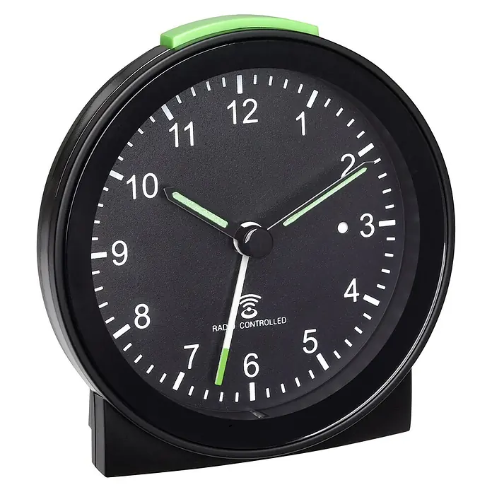 TFA Dostmann Funkwecker 60.1517.01 - Analoges Display, Batteriebetrieben, Schwarz, 8,1 cm - Nahaufnahme eines schwarzen Radioweckers mit grünem Knopf oben, der 10:11 Uhr anzeigt.