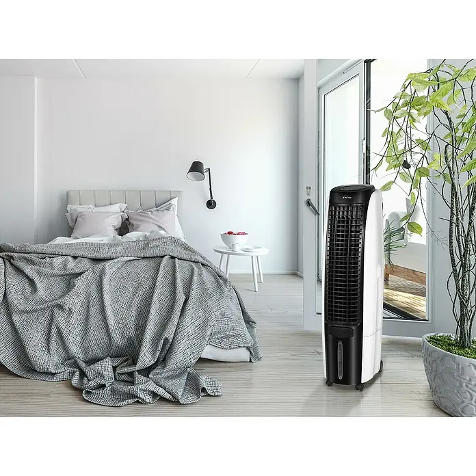 Purline Rafy Climatizador evaporativo 125 - Blanco, Altura: 124 cm, 200 W - Vista de la habitación con un enfriador de aire de torre. El ventilador de torre blanco y negro está al lado de una planta en maceta en la habitación.