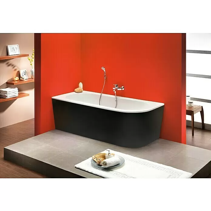 Ottofond Badewanne Siesta Corner - 178 x 78 cm, Sanitäracryl, Schwarz/Weiß, Rechts - Eine moderne freistehende Badewanne mit weißer Innenseite und schwarzer Außenseite, auf einer gefliesten Plattform in einem modernen Bad mit oranger Wand.
