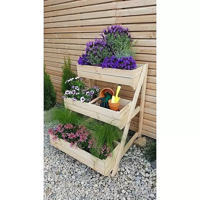 Promadino Pflanzkasten - Holz, Braun - Ein helles Holz-Pflanzregal mit verschiedenen bunten Pflanzen und Gartengeräten, vor einem Holzaun.