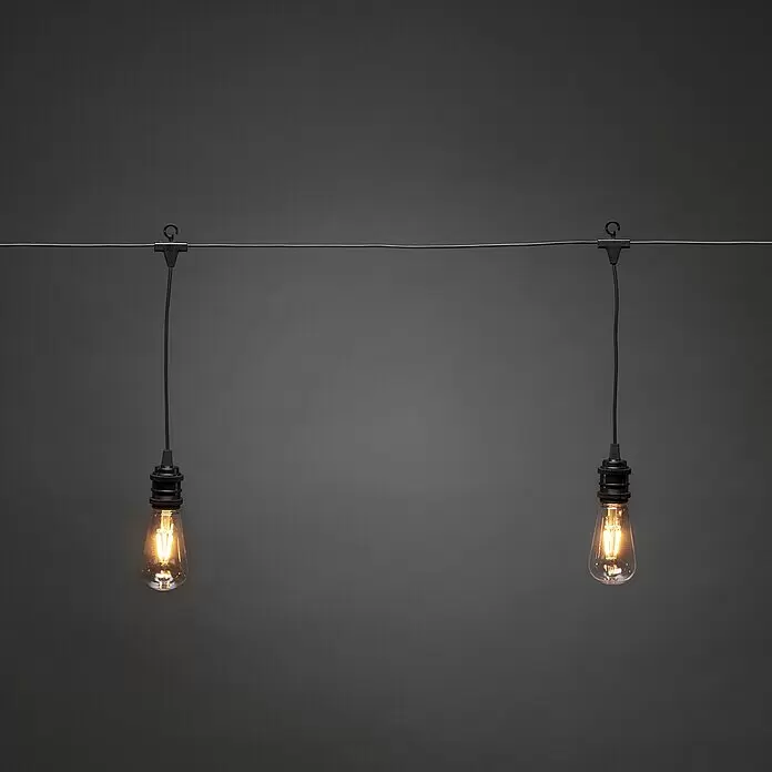 Konstsmide LED-Lichterkette Globe - Außen, Lichtfarbe: Bernstein, Netzbetrieben, Oval - Zwei beleuchtete Vintage-LED-Glühbirnen an einer schwarzen Lichterkette.