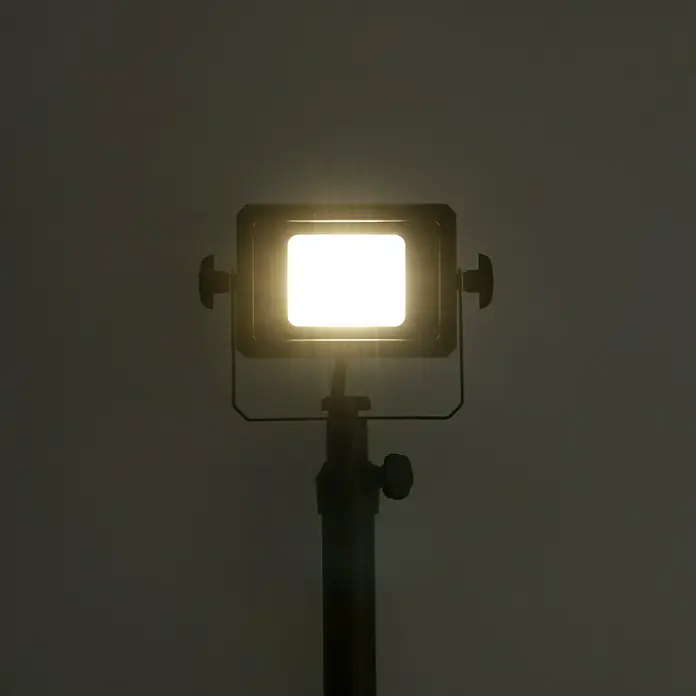 Profi Depot LED-Strahler - 10 W, 1.650 lm, 4.000 K, L x B x H: 53,5 x 62 x 135,6 cm, IP65 - Eine Nahaufnahme einer LED-Fotoleuchte auf einem Stativ, die helles, warmes Licht ausstrahlt und für Foto- und Videoaufnahmen geeignet ist.