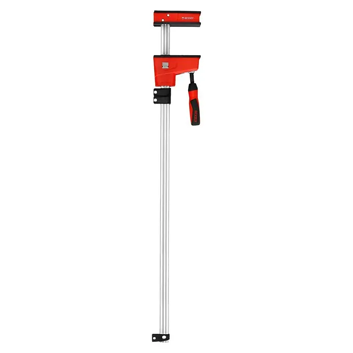 Bessey Tornillo Korpus REVO KRE - Anchura de sujeción: 800 mm, Fuerza de tensión: 8.000 N, Apertura máxima: 95 mm - Se muestra una abrazadera de engranaje Bessey roja con una barra guía plateada sobre un fondo negro.