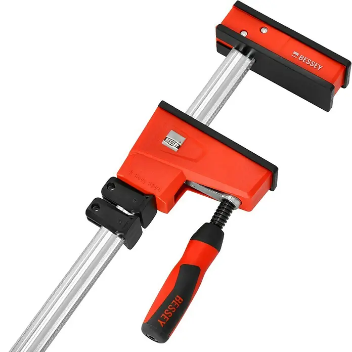 Bessey Tornillo Korpus REVO KRE - Anchura de sujeción: 800 mm, Fuerza de tensión: 8.000 N, Apertura máxima: 95 mm - Un primer plano de una abrazadera para gabinetes BESSEY REVO con mango rojo y brazo deslizante sobre un fondo negro.