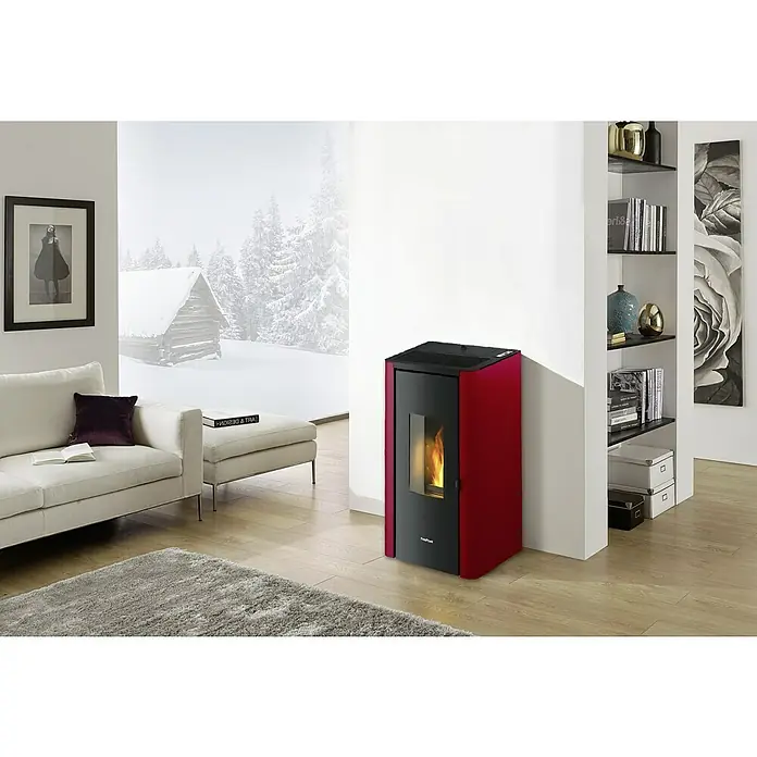FreePoint Pelletofen Indigo - 7 kW, Raumheizvermögen: 57,6 m³ - 156 m³, Bordeaux - Ein roter FreePoint Pelletofen steht in einem modernen Wohnzimmer, das Wärme und Stil vereint. Der Ofen bietet effiziente Heizleistung in ansprechendem Design.