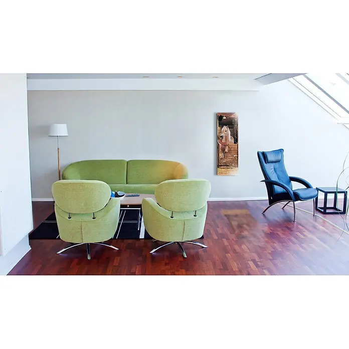 Papermoon Infrarot-Glasbildheizkörper Riding Horse - 400 x 1.200 mm, 500 W - Wohnzimmer mit zwei grünen Sesseln, einem grünen Sofa und einem schwarzen Ledersessel mit Tisch, der dem Raum einen stilvollen Touch verleiht.