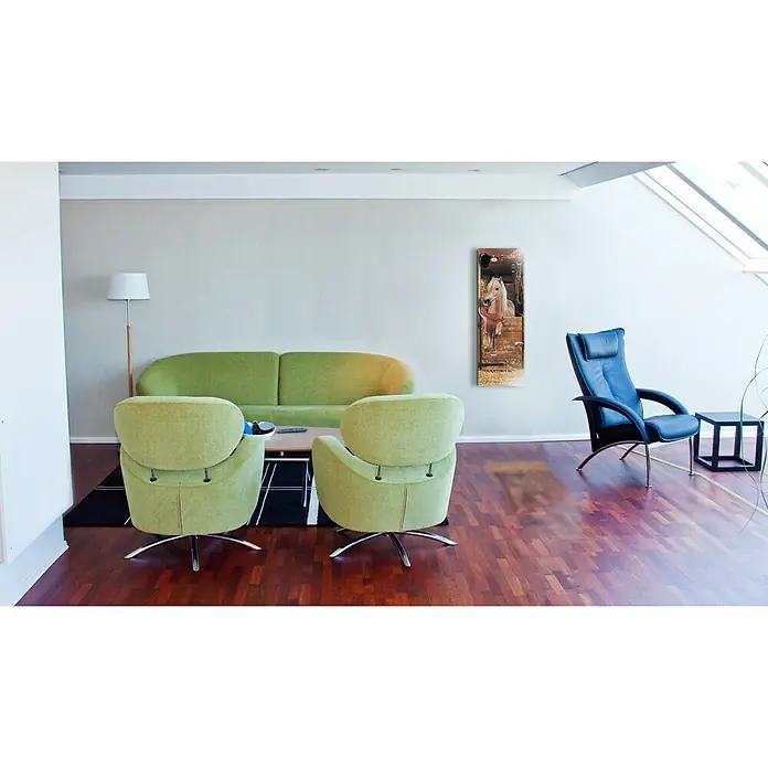 Papermoon Infrarot-Glasbildheizkörper Riding Horse - 400 x 1.200 mm, 500 W - Wohnzimmer mit zwei grünen Sesseln, einem grünen Sofa und einem schwarzen Ledersessel mit Tisch, der dem Raum einen stilvollen Touch verleiht.