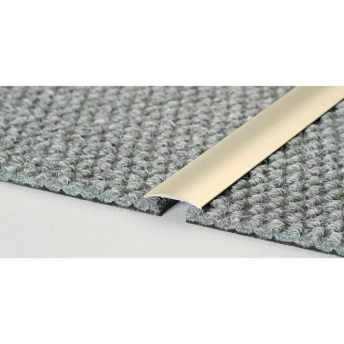 LOGOCLIC Übergangsprofil 130 - Sahara, 1 m x 30 mm x 3,9 mm, Montageart: Kleben - Detailaufnahme einer beigefarbenen Teppichschiene, die zwei graue Teppichstücke verbindet und einen sauberen Übergang schafft.