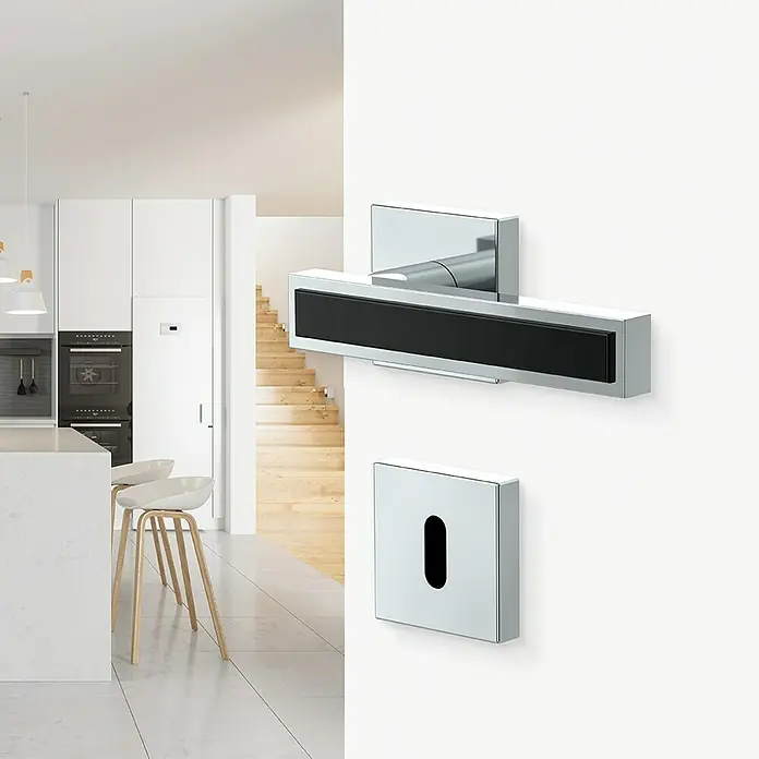 Diamond Doors Black Edition Zimmertürgarnitur Tyler Black - Chrom, Stärke Tür: 40 mm - 45 mm, Buntbart - Nahaufnahme eines modernen Türgriffs und Schlüssellochs mit glänzender Chromoberfläche und schwarzem Akzent.