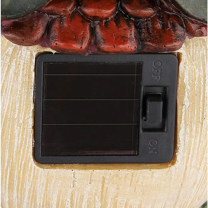 Globo Solar-Dekoleuchte Hütte - L x B x H: 13,3 x 12,5 x 17,5 cm, Bunt, IP44 - Nahaufnahme des Solarpanels mit dem Ein-/Ausschalter eines Dekoartikels. Das Panel ist schwarz und rechteckig.