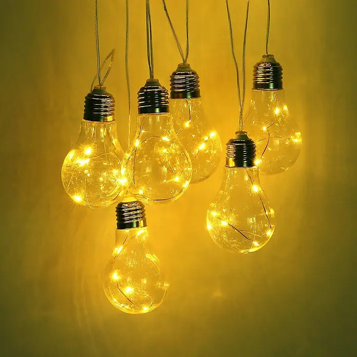 Globo Solar-Lichterkette - Klar - Nahaufnahme von einem Haufen dekorativer Glühbirnen mit kleinen LED-Lichtern, die warmes Licht ausstrahlen.