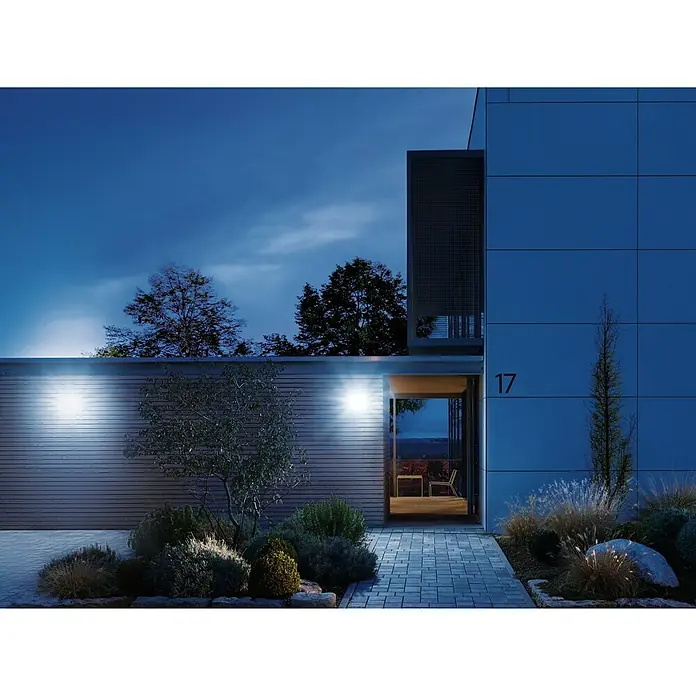 Steinel LED-Sensor-Strahler XLED home 2 S weiß - 13,7 W, L x B x H: 161 x 180 x 218 mm, Weiß, IP44 - Moderne Hausfassade mit Außenbeleuchtung, die die Architektur hervorhebt und für Sicherheit sorgt. Die Hausnummer 17 ist gut sichtbar.