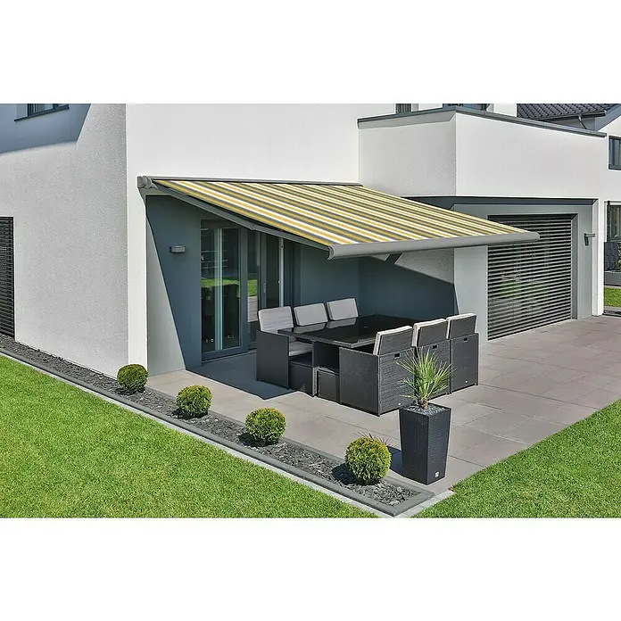 Deyo Limassol Vollkassettenmarkise - Gelb/Grau/Beige, Farbe Gestell: Weißaluminium Feinstruktur, Breite: 5,5 m, Ausfall: 3,5 m - Moderne Terrasse mit stilvoller Markise. Die gelb-grau gestreifte Markise bietet Schatten über der eleganten Gartengarnitur.