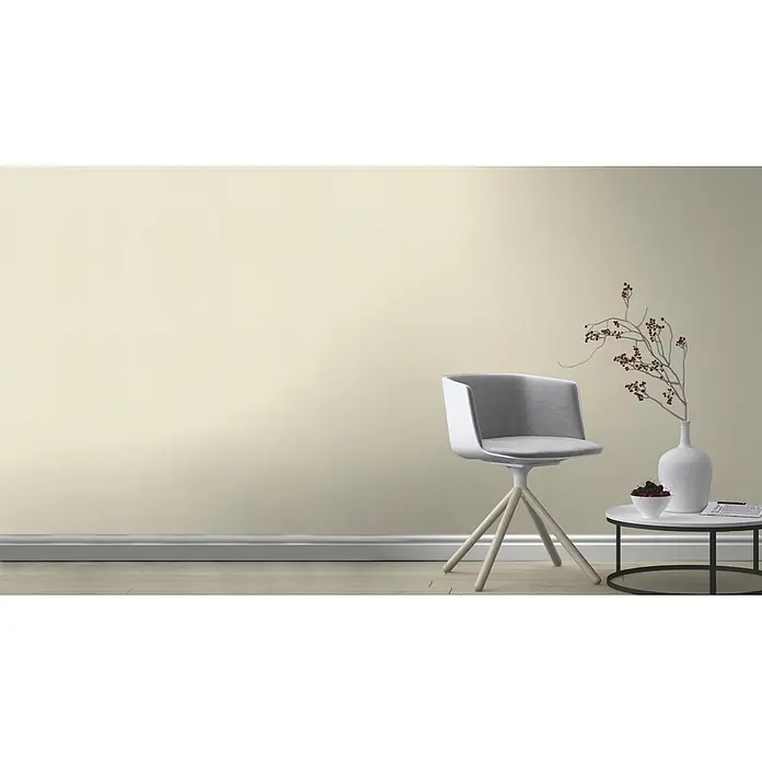 Rasch Vliestapete - Beige, Uni, 10,05 x 0,53 m, Matt, Feine Struktur - Einladendes Interieur mit einem modernen grauen Stuhl, einem stilvollen Beistelltisch und einer eleganten Vase, die das harmonische Ambiente hervorheben.