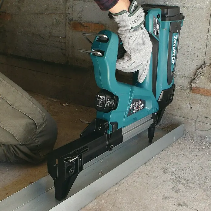 Makita Akku-Gasnagler GN420CLSE - 7,2 V, 2 Akkus, Länge Nagel: 15 mm - 40 mm - Der Makita Akku-Nagler beim Befestigen einer Metallschiene, ein unverzichtbares Werkzeug für präzise Bauarbeiten.
