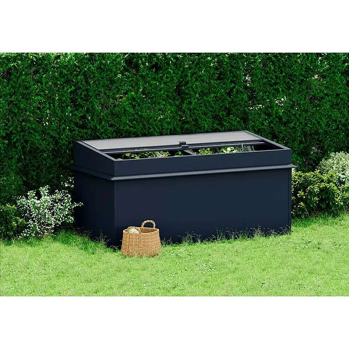 Gardol Frühbeet-Aufsatz - L x B x H: 198 x 98 x 23 cm - Das Bild zeigt eine stilvolle, dunkelblaue Pflanzkiste im Garten. Ein Weidenkorb steht daneben, umgeben von üppigem Grün.