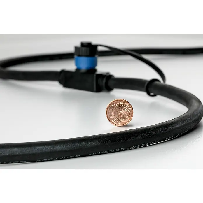 Paulmann Plug & Shine LED-Gartenspot-Set - 3 W, Erdspieß, Höhe: 26 cm - Nahaufnahme einer schwarzen Kabelverbindung mit blauem Verbinder und einer 1-Euro-Cent-Münze zur Größenorientierung.