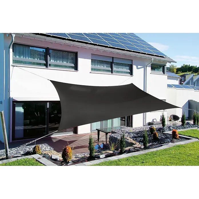 Sunfun Toldo vela Mojave - Antracita, Rectangular, 360 x 360 cm - Vela solar gris oscuro que proporciona sombra en un patio con un jardín de rocas, adyacente a una casa moderna con paneles solares.