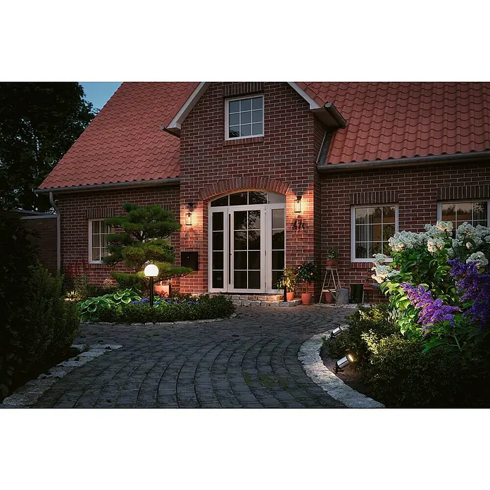 Paulmann Plug & Shine Aplique para exterior LED - 10 W, Blanco cálido, IP44 - Acogedora área exterior de una casa de ladrillo con luces exteriores que iluminan el camino y crean un ambiente cálido.