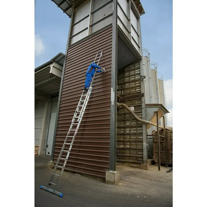 Krause Stabilo Seilzugleiter - Anzahl Tritte: 40 Stk., Arbeitshöhe: 10,95 m, Aluminium - Ein Handwerker benutzt eine Aluminium-Mehrzweckleiter, um an einer hohen Gebäudefassade zu arbeiten, was die Vielseitigkeit der Leiter hervorhebt.