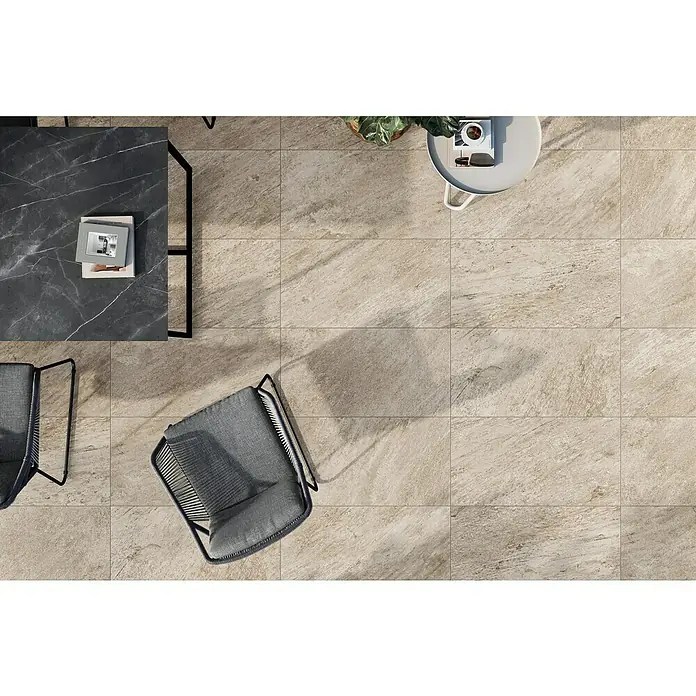 Atlas Concorde Solution Regent Terrassenfliese Ivory - 45 x 90 x 2 cm, Beige/Braun, Matt - Einladender Außenbereich mit Natursteinfliesen, grauen Stühlen und einem stilvollen Marmortisch. Perfekt für entspannte Stunden im Freien.