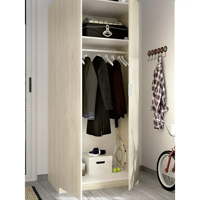 Dekit Armario para ropa Essen - L x An x Al: 52 x 81 x 184 cm, Natural - Un armario de madera claro y abierto presenta ropa, una raqueta de tenis, pelotas de tenis y una maleta en un estante para guardar en un pasillo.