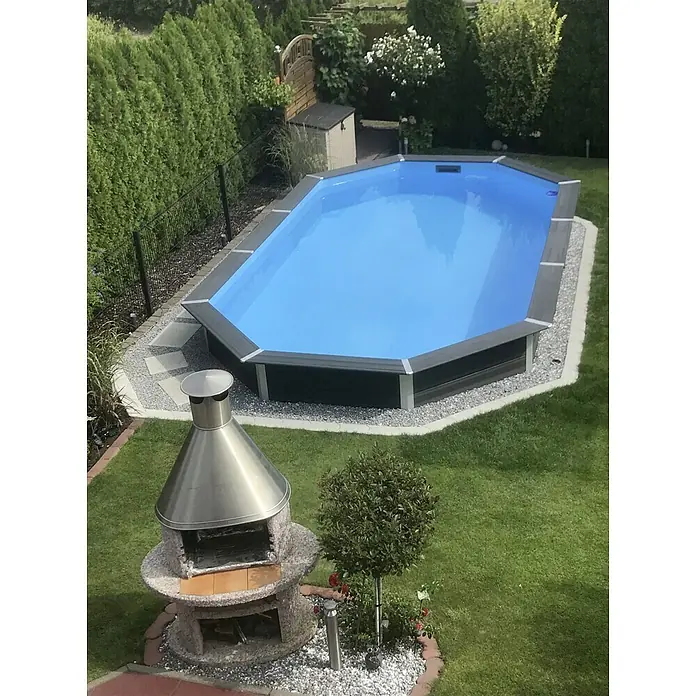 Gre Avantgarde WPC-Pool Avantgarde - L x B x H: 804 x 386 x 124 cm, 27.000 l, Dunkelgrau - Gartenszene mit einem blauen Pool, einem Steingrill und gepflegtem Rasen. Der Pool lädt zum Entspannen ein, während der Grill zum Verweilen einlädt.