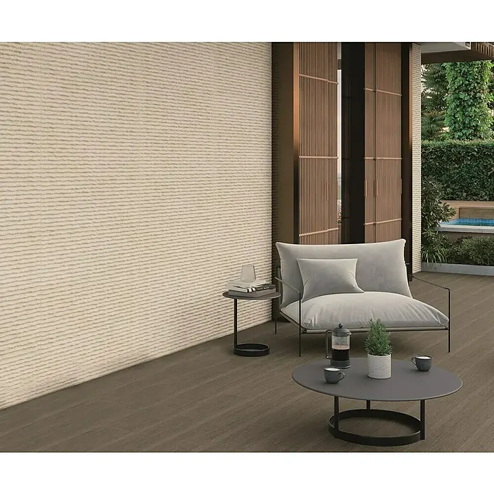Verblendstein Niagara Bone - 60 x 20 cm, Beige, Steinoptik - Moderne Terrasse mit bequemen Loungesessel und Couchtisch. Die Wandgestaltung ist mit einer strukturierten, horizontal gerippten Textur versehen.
